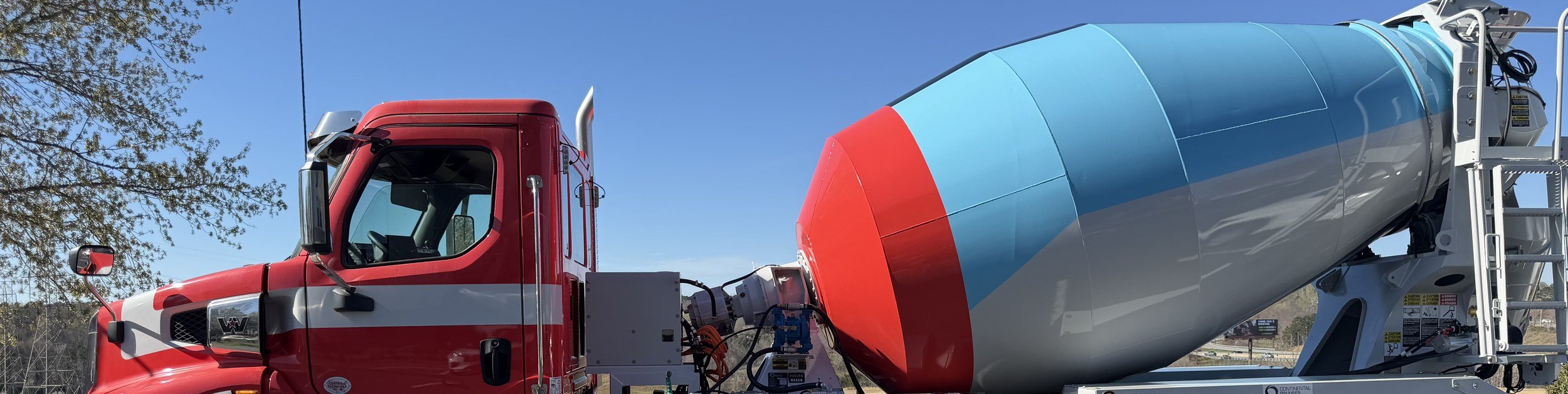 A Grooms Heavy Truck Sales mixer truck against a blue sky